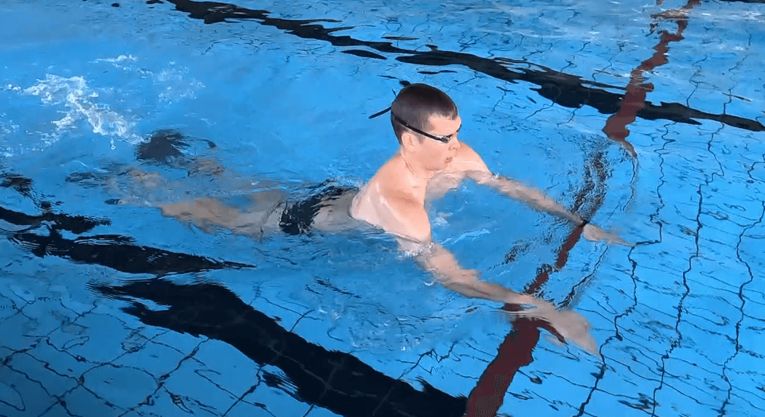 Schwimmer hebt sich aus dem Wasser, hält Arme und Beine gestreckt, um mehr Auftrieb und Stabilität zu haben.